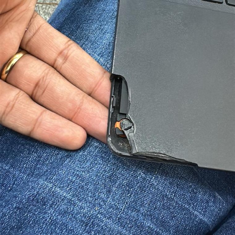 Canto de notebook com a carcaça trincada e a dobradiça descolada da tampa