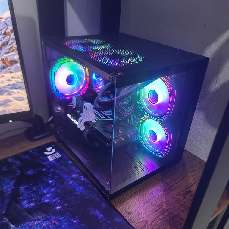 Gabinete de PC gamer com painel lateral de vidro e coolers RGB acesos, com a placa de vídeo à mostra